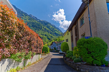 Obraz premium Scenic view of mountain panorama and road at Swiss village of Sisikon on a sunny spring day. Photo taken May 22nd, 2023, Sisikon, Switzerland.