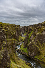 Fototapeta na wymiar Unique rugged landscape of Fjaðrárgljúfur canyon covered by green moss, located in southern Iceland. 