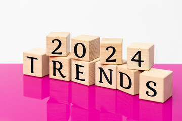 2024 trends, lettering on wooden blocks, beautiful fuchsia and white background, new year trend update concept, close up,