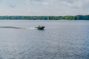 Green motor boat riding on Daugava river next to city Ikskile in Latvia, Baltic States