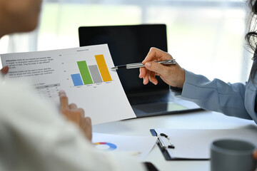 Professional financier team analyzing statistics document at co working space