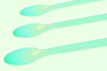 Green plastic spoons for camping, isolated on white surface