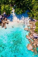 Anse Lazio Praslin Seychelles is a young couple of men and women on a tropical beach during a...