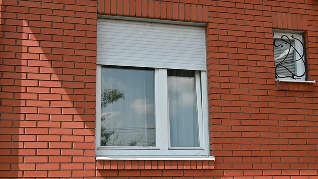 The blinds are closing. Blinds are installed on the window.