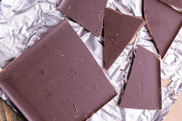 A broken chocolate bar in a paper and foil package