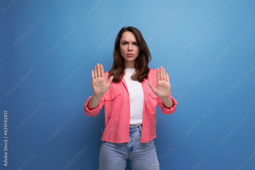 Canvas Prints portrait of a young woman with hair below her shoulders in jeans and a shirt with a disagree gesture