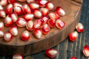 Red pomegranate seeds on the table and the board