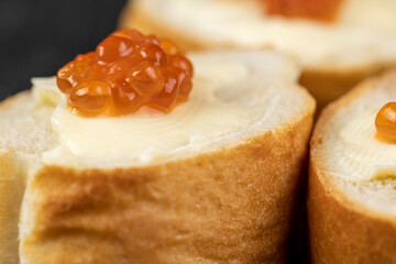 Thinly sliced baguette with salmon caviar and butter