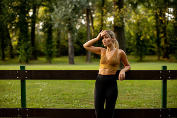 Pretty young woman resting after outdoor training