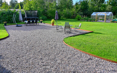 Back yard with seating area on gravel and lawn around