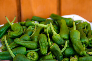 Pimientos verdes sobre un plato en un fondo de madera