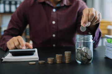 accountant working on desk in office using calculator and laptop to calculate budget. concept finance and accounting in morning light.