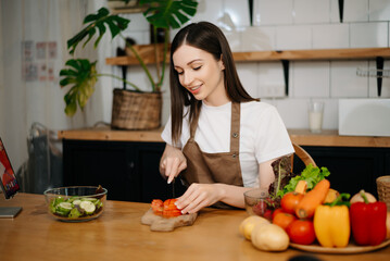 young woman with cutting board of cut lettuce at kitchen. healthy food concept.