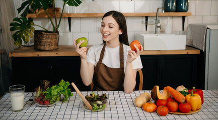 young woman with cutting board of cut lettuce at kitchen. healthy food concept.