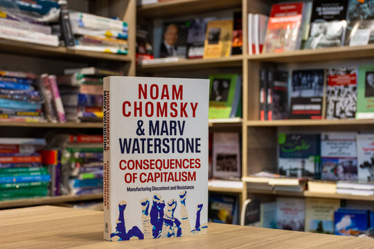 Close up Noam Chomsky and Marv Waterstone's Consequences of Capitalism book in the bookstore.