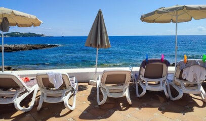  Front view of the blue waters of the sea of Majorca. There can be seen a set of empty sandbeds and sun