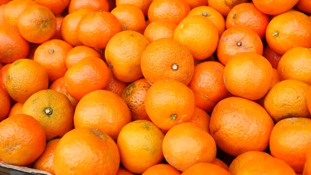 Box with fresh organic tangerines displayed for sale in greengrocery. High quality 4k footage