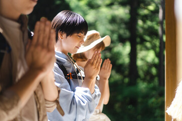 山の中にある神社にお参りする日本人グループ