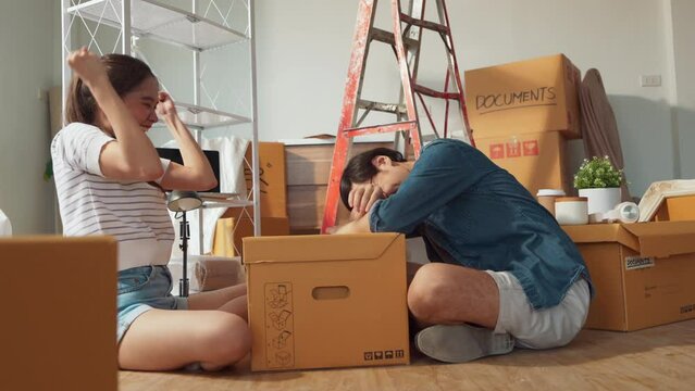 Young cheerful asian adult couple having fun while arm wrestling for dominance in the house.Home renovate decision organize house arrangement with fun and humor family concept