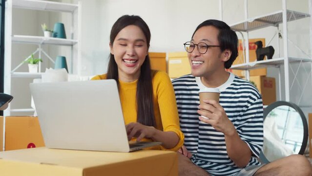 smiling enjoy home moving resting happiness asian marry couple sit on floor using laptop searching truck delivery for new home relocation home moving ideas concept,asian people packing boxes for move