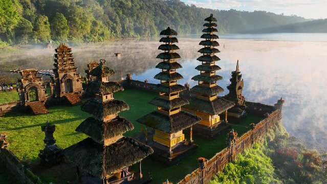 traditional balinese Pura Ulun temple on the morning lake in Bali, Indonesia, Indonesian culture, foggy sunrise on a lake in Bali