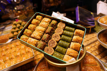 A sample package made up of various types of classic Turkish desserts including baklava, pistachio roll and others - obrazy, fototapety, plakaty