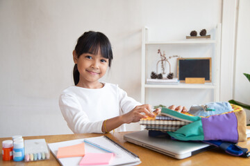 Pupil child put books and notes into backpack. School supplies.Back to school concept. Kid prepare for studies. Portrait cute little girl packing backpack .