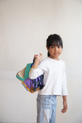 portrait a student carrying a backpack behind a white background.