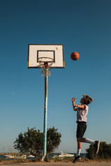 Child throwing ball into hoop on court