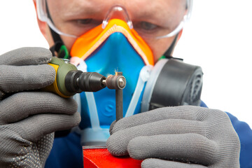 Male locksmith worker processes metal with engraving drill cutting. The work of the dremel...