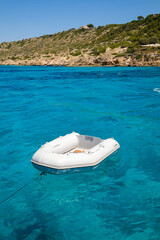 Empty inflatable boat in turquoise sea on sunny day