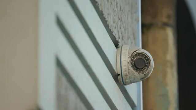Broken Security Camera on the wall of an office building: Dirty CCTV Camera is abandoned