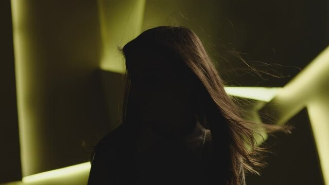 Close up portrait of pretty brunette female model . Beautiful attractive face of young woman . Hair flowing or blowing in wind . Face Changes Depending on the Lighting . Shadow and light movement . 