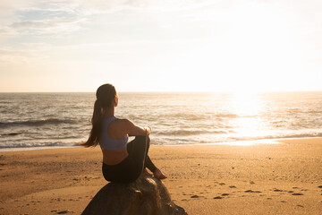 Happy calm millennial caucasian woman sit on rock, enjoy vacation, rest and peace at sea beach, sun...