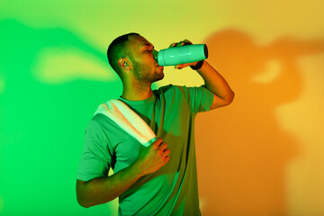 African american fitness man drinking healthy liquid in studio