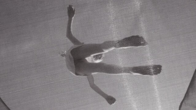 Bottom up view on girl bouncing on a trampoline. Slow motion full HD video child jumping on the trampoline