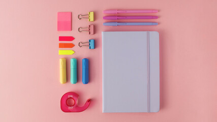 Stylish flatlay of stationery, notepad and paints on a pink background. Back to school.