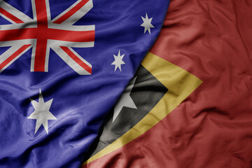 big waving realistic national colorful flag of australia and national flag of east timor .