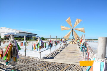Windmills and bamboo bridges with a bright blue sky in the salt fields