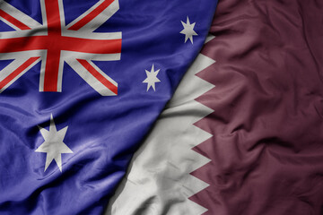 big waving realistic national colorful flag of australia and national flag of qatar .