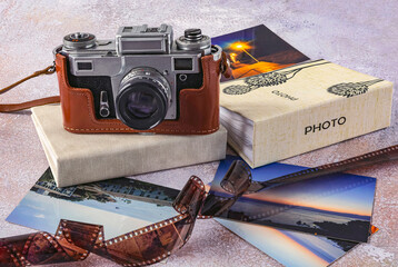 Old camera, color photos, photo film and photo albums on a light background. World Photography Day,...