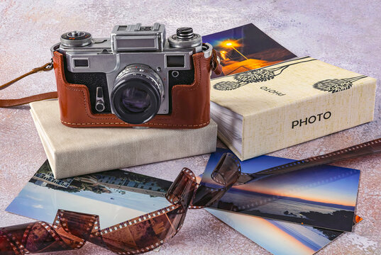 Old camera, color photos, photo film and photo albums on a light background. World Photography Day, August 19, concept