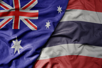 big waving realistic national colorful flag of australia and national flag of thailand .