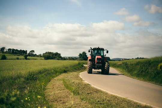 Fototapeta tractor conduciendo por camino asfaltado