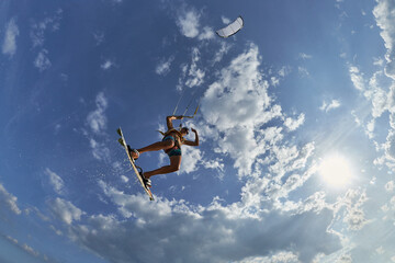 Kite surfer jumps with kiteboard in transition