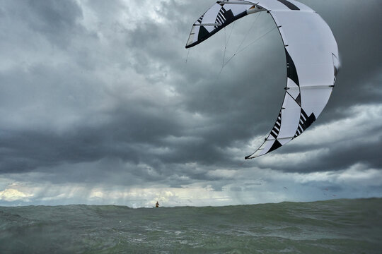 Kitesurfer kitesurfing on the sea with kite in the foreground