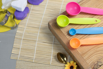 Plastic measuring spoon placed on a wooden tray, ready to cook or dessert