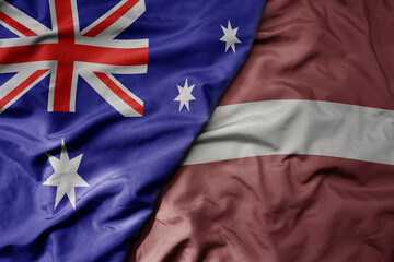 big waving realistic national colorful flag of australia and national flag of latvia .