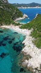 Aerial view of the rocky shoreline of Corfu, Greece with its crystal clear blue ocean waters.