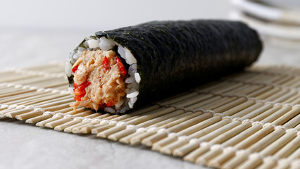 Whole uncut homemade sushi roll with vegetables and canned tuna fish. © Fotema